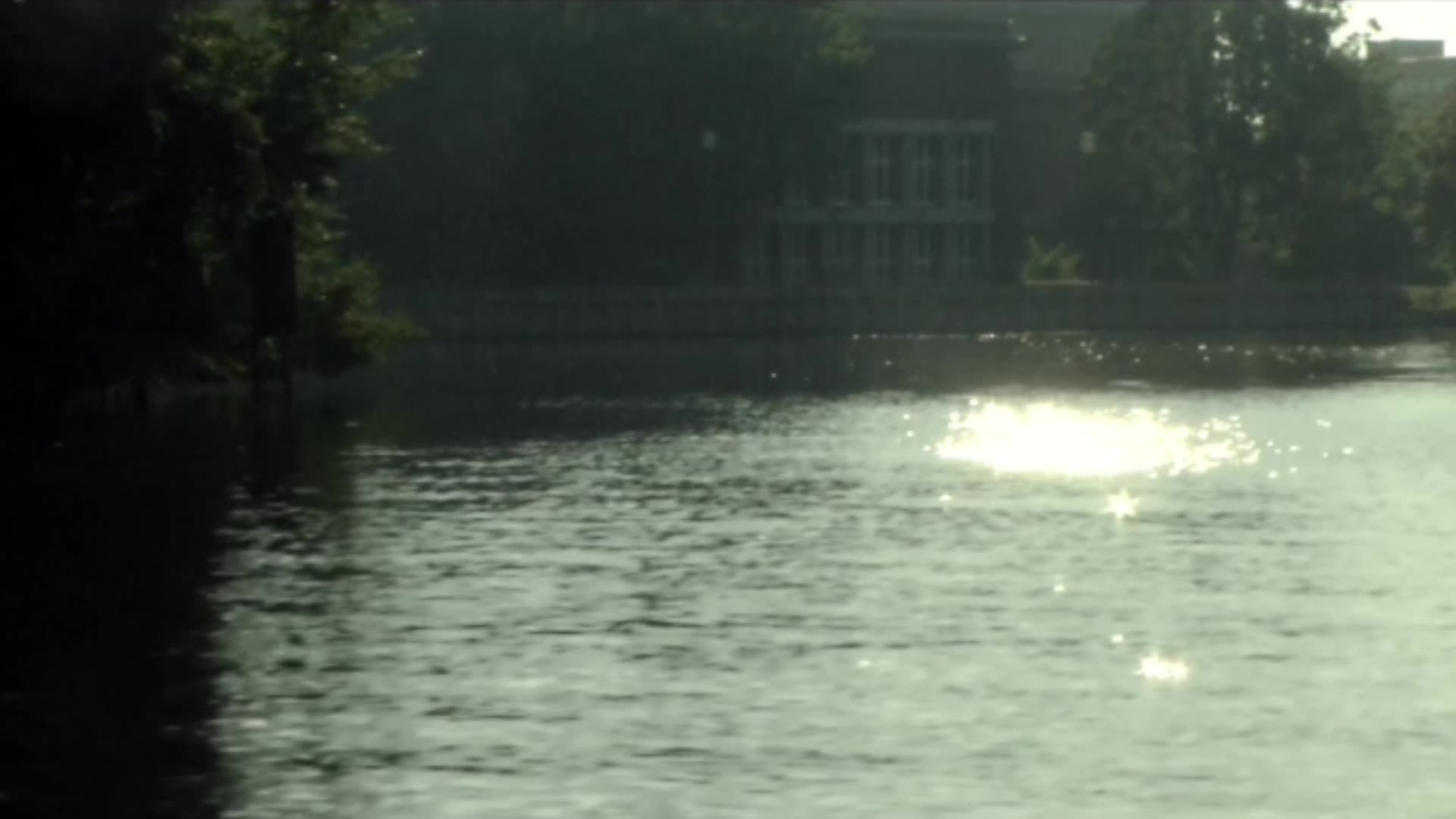 The Funkhaus Berlin seen across the Spree, sun glittering on the water, trees on the bank